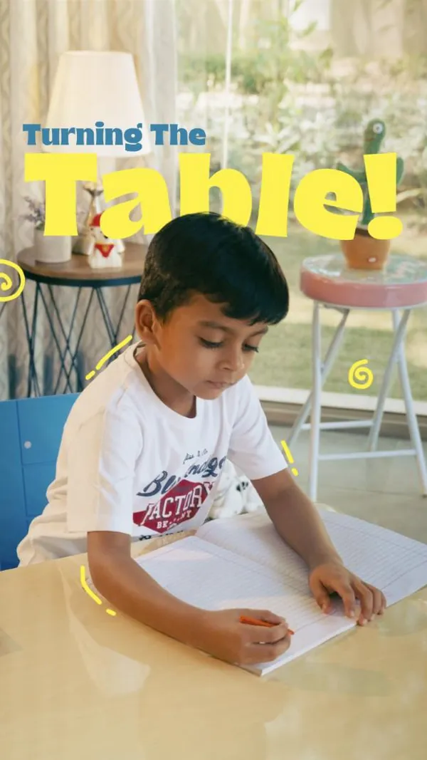 Turning the table: a boy colours in his notebook at a sunny study desk.