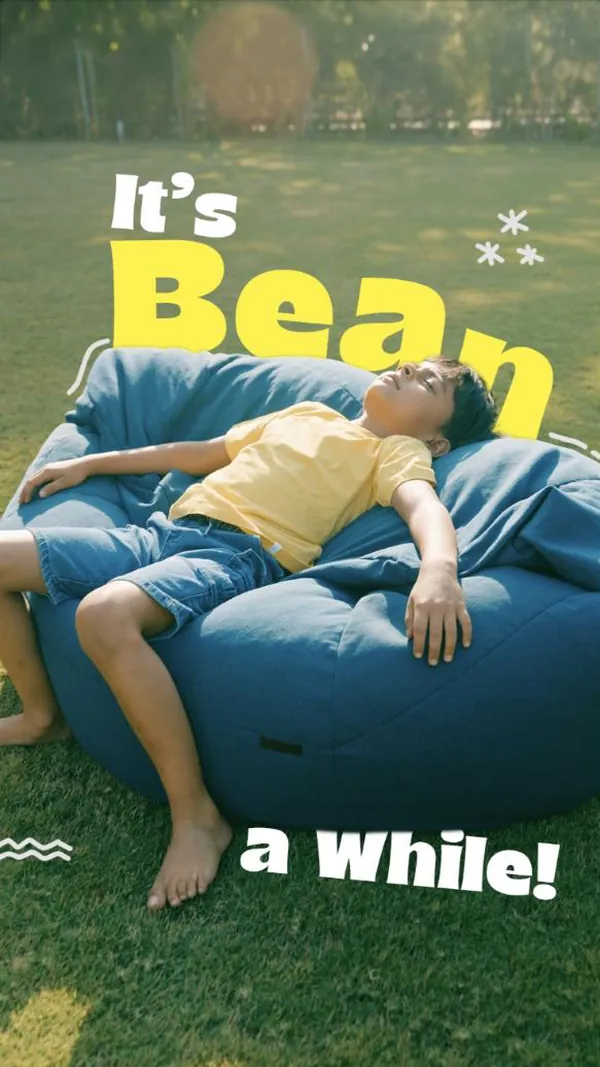 It’s bean a while: a boy stretches out on a blue bean bag in the sun.