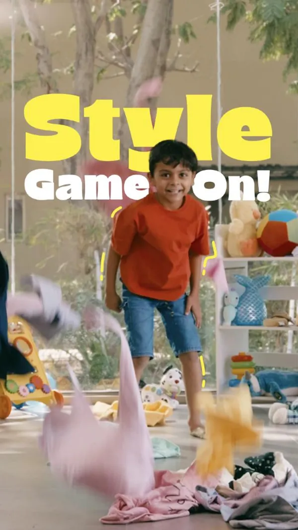 Style game on: a boy in denim shorts grins as clothes fly past.
