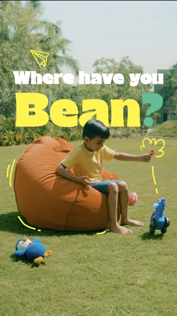 Where have you bean? A boy plays with a pull-along toy beside his orange bean bag.