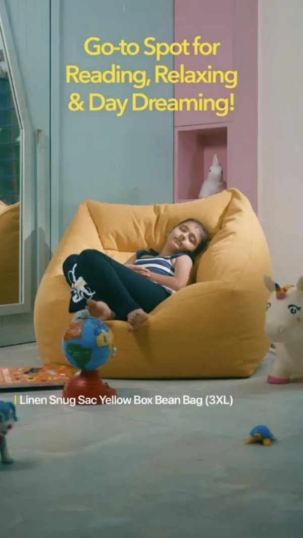 A girl dozes in a big yellow bean bag, the go-to spot for reading and daydreams.