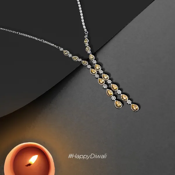 A yellow-diamond necklace runs down the fold toward a lit diya.