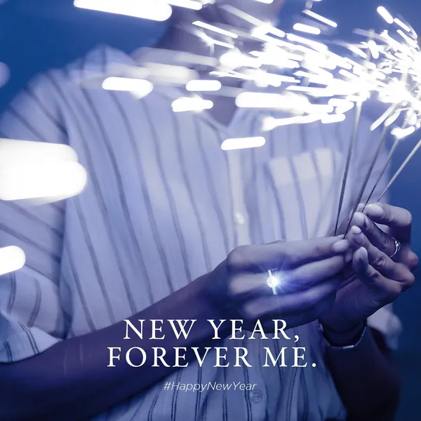 New Year: sparklers fizzing around a hand wearing a diamond ring.