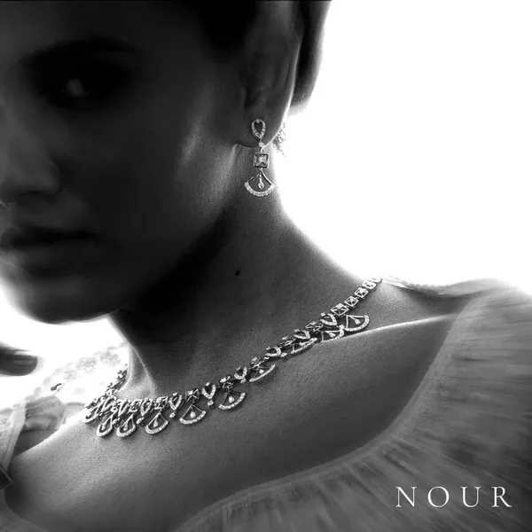 Drop earrings and a delicate necklace in soft side light.