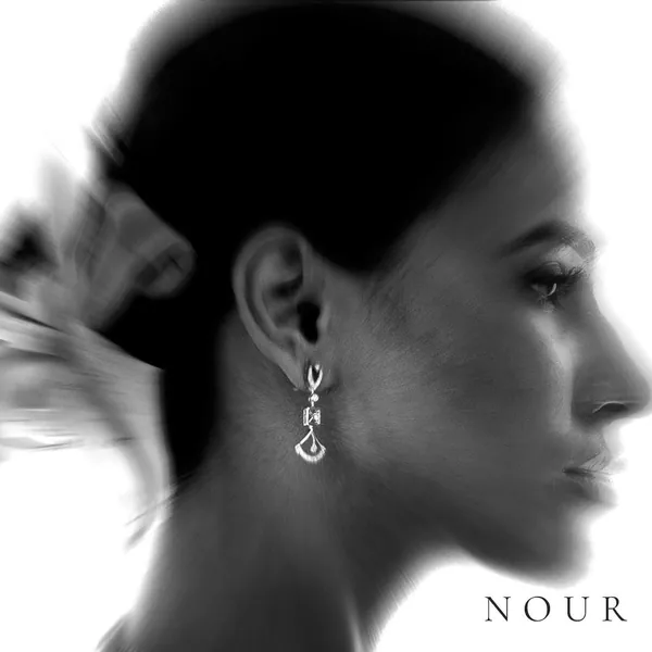 In profile: one long drop earring while the rest fades to white.