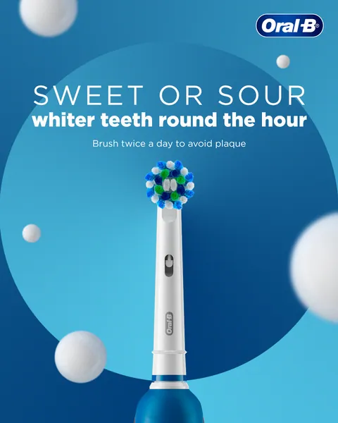 Alternate layout: a brush head amid floating white spheres, 'Brush twice a day to avoid plaque'.