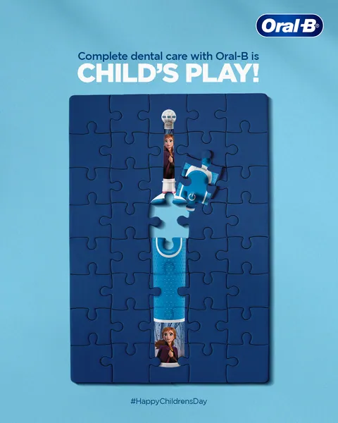 Children's Day: a Frozen kids' brush forms the missing pieces of a blue jigsaw puzzle.