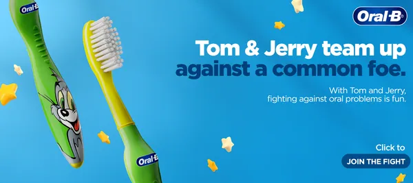 Tom & Jerry banner, close-up: a green kids' brush with Tom's face among gold stars.