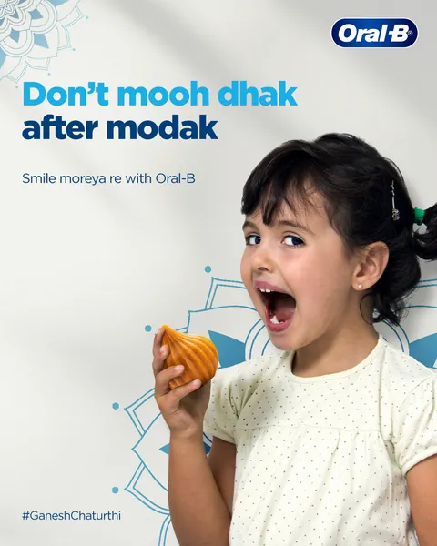 Ganesh Chaturthi: a wide-mouthed girl holds a modak, 'Don't mooh dhak after modak'.