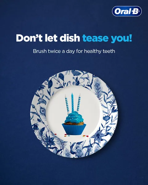 A pun on 'dish tease': a candle-topped blue cupcake on a blue floral plate.