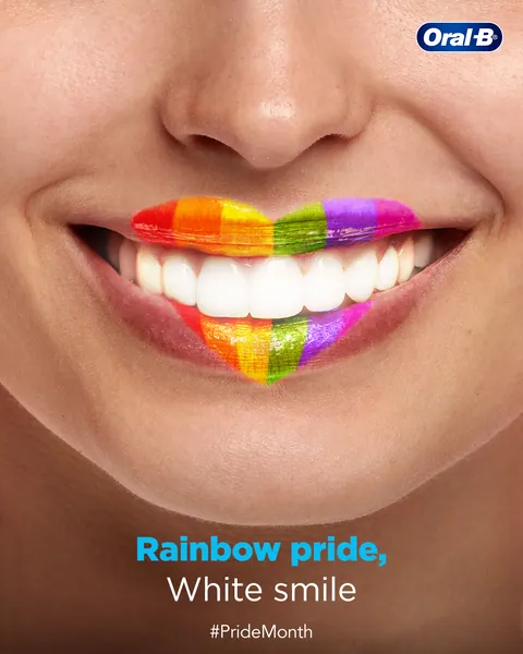 Rainbow-painted lips frame bright white teeth in this Pride Month post: 'Rainbow pride, White smile'.