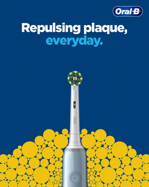 Yellow dots scatter away from a pale blue electric brush: 'Repulsing plaque, everyday'.