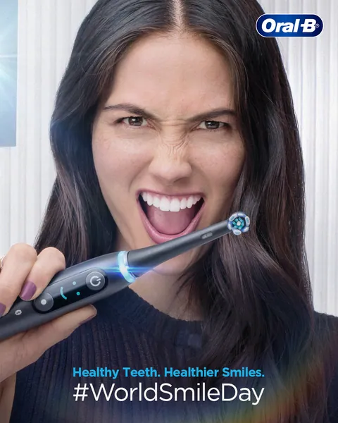 World Smile Day: a woman flashes a fierce grin with a black iO brush in hand.