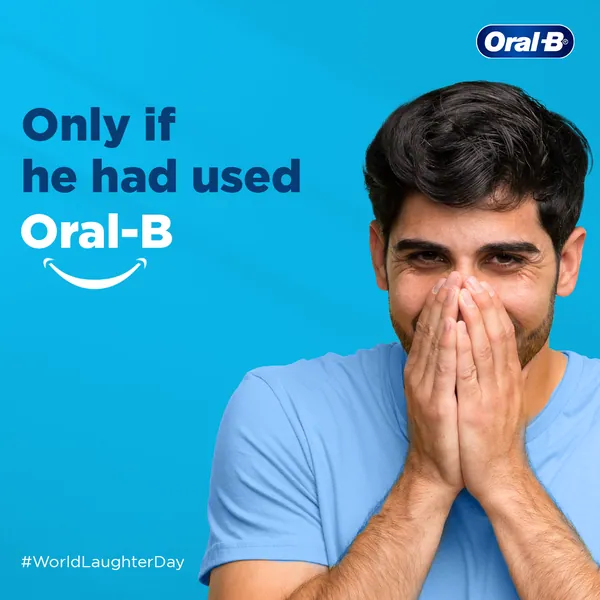 Laughter Day: a man hides his grin behind his hands, 'Only if he had used Oral-B'.